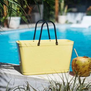 Soft yellow tub bag with a coconut next to a pool