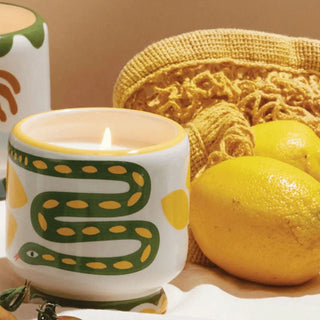 two lemons with a candle in a ceramic container