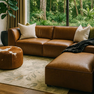 Sectional leather sofa in a room with a garden view and a cowhide covered ottoman