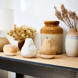 Pear and apple shaped pottery ornaments on a shelf