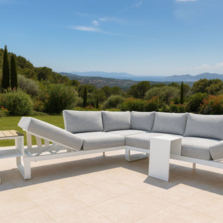 Outdoor patio set with a sectional sofa and coffee table on a tiled patio with a scenic view.