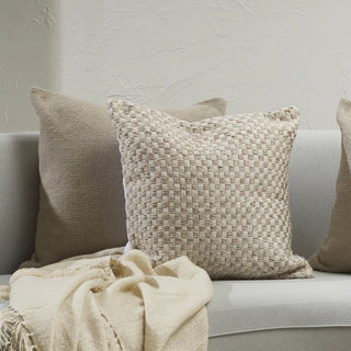 Textured pillows on a sofa with a neutral background