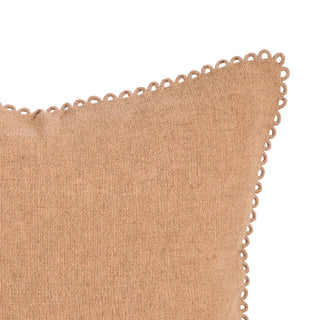 Close-up of a tan woven throw pillow with a decorative scalloped edge, shown against a plain white background.