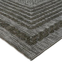 Close-up of a textured gray rug with a geometric pattern