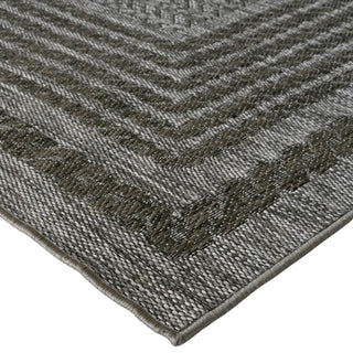 Close-up of a textured gray rug with a geometric pattern