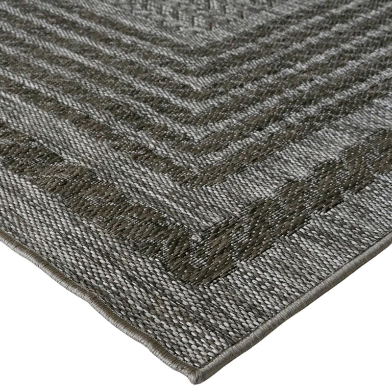 Close-up of a textured gray rug with a geometric pattern