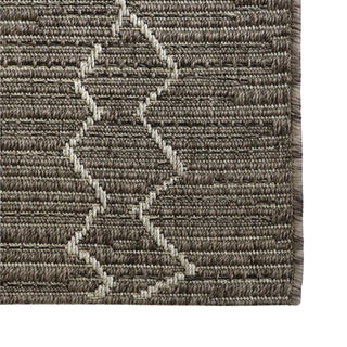 Close-up of a textured brown rug with geometric pattern