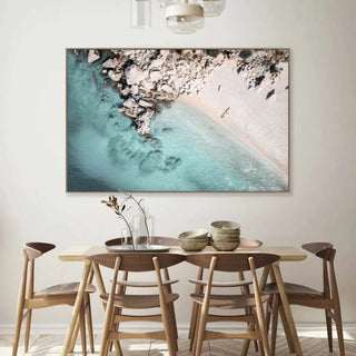 Dining room with a large abstract painting of a beach scene on the wall.