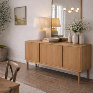 Wooden sideboard in a living room with decor items and a mirror.