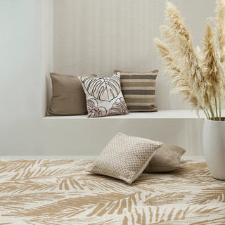 Decorative pillows on a bench with a patterned rug and potted plant in the background