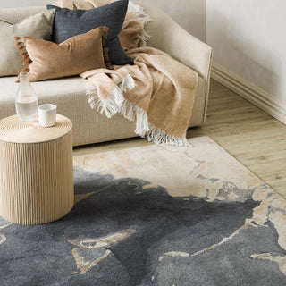 Living room with a beige sofa, patterned rug, and wooden side table.