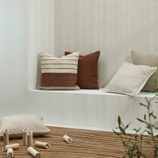 Decorative pillows on a ledge with a neutral background