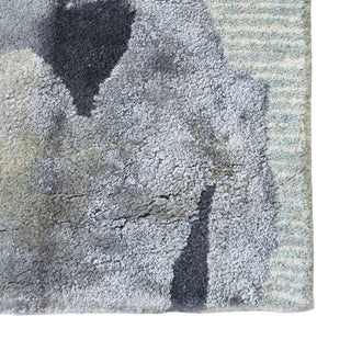 Textured rug with a mix of gray, black, and beige colors on a white background