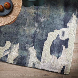 Textured area rug with abstract design on a wooden floor