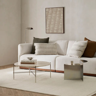 Modern living room with a white sofa, decorative pillows, and a coffee table.