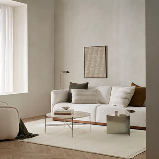 Modern living room with a white sofa, coffee table, and decorative pillows.