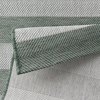 Close-up of green woven rug with a textured pattern