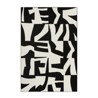 Black and white abstract patterned rug on a plain background