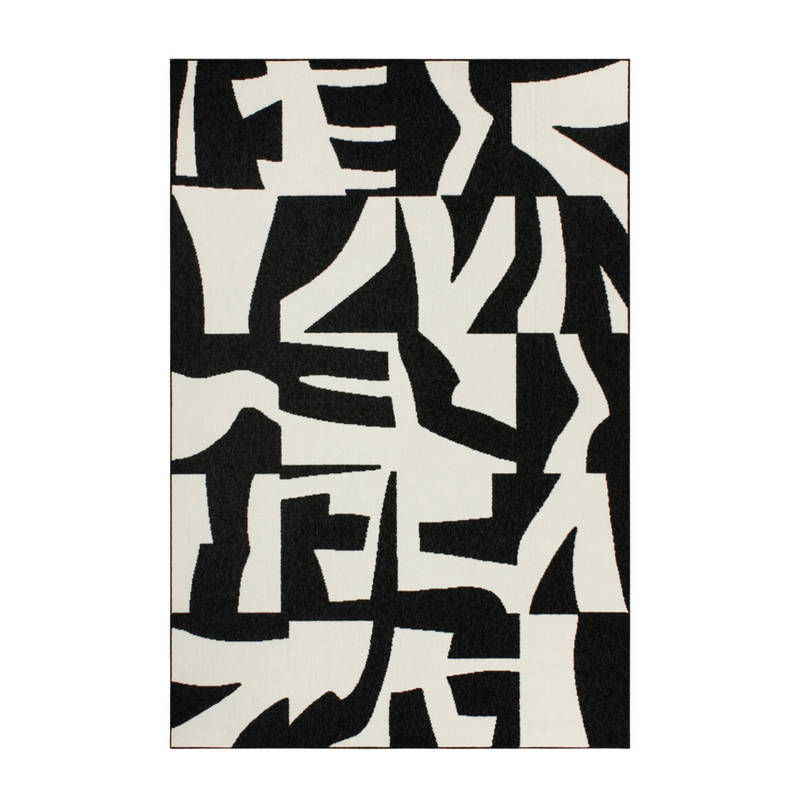 Black and white abstract patterned rug on a plain background