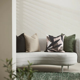 Gray sofa with decorative pillows against a neutral wall