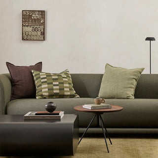 Living room with a gray sofa, decorative pillows, and a small round table.