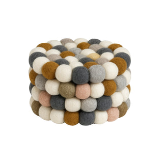 Set of four neutral felt ball coasters in cream, mustard, grey, and blush tones, handcrafted from New Zealand wool.