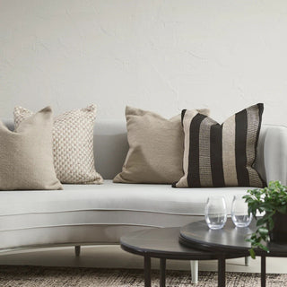 White sofa with decorative pillows and a small table in a living room setting.
