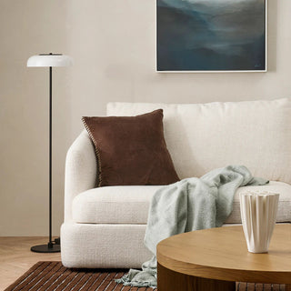 Cozy living room with a beige sofa, brown pillow, and wooden coffee table.