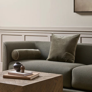 Thyme sofa with decorative pillows in a room with wooden coffee table and framed artwork.