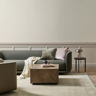 Modern living room with a gray sofa, wooden coffee table, and decorative items.
