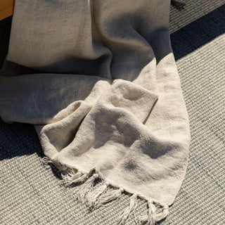 Beige towel with fringes on a textured surface