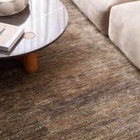 Brown patterned carpet in a living room setting with a coffee table and sofa.