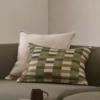 Checkered pillow on a gray sofa with a neutral background