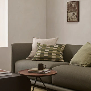 Gray sofa with decorative pillows and a small table in a living room setting.