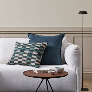 White sofa with decorative pillows and a small wooden table in a living room setting.