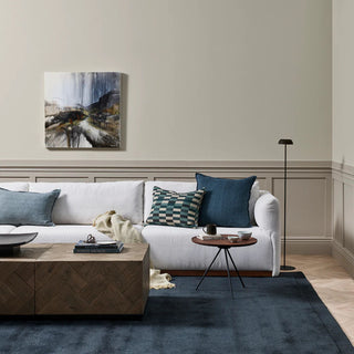 Modern living room with a white sofa, wooden coffee table, and decorative pillows.