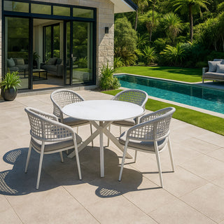 Outdoor patio set with table and chairs near a pool