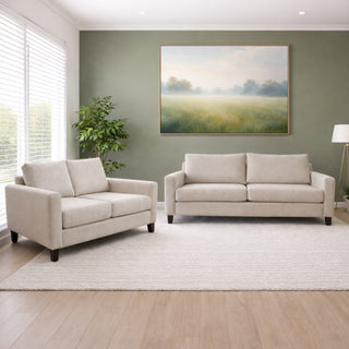 Beige sofa set in a living room with a painting on the wall.