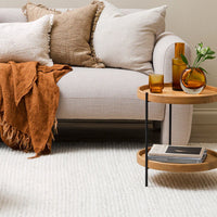 Cozy living room with a beige sofa, decorative pillows, and a wooden side table.
