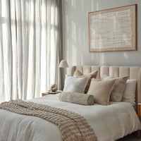 Neatly made bed with pillows and a blanket in a bedroom setting.