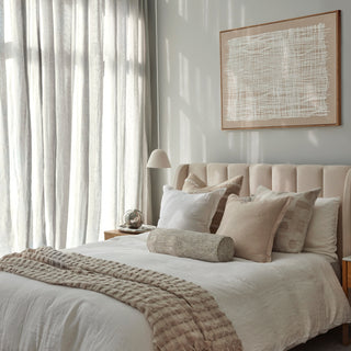 Neatly made bed with pillows and a blanket in a bedroom setting.