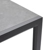 Corner of a table with gray concrete top and black metal frame on a white background