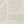 Close-up of a textured beige rug with a subtle pattern on a white background