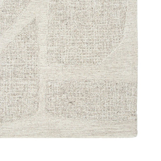 Close-up of a textured beige rug with a subtle pattern on a white background