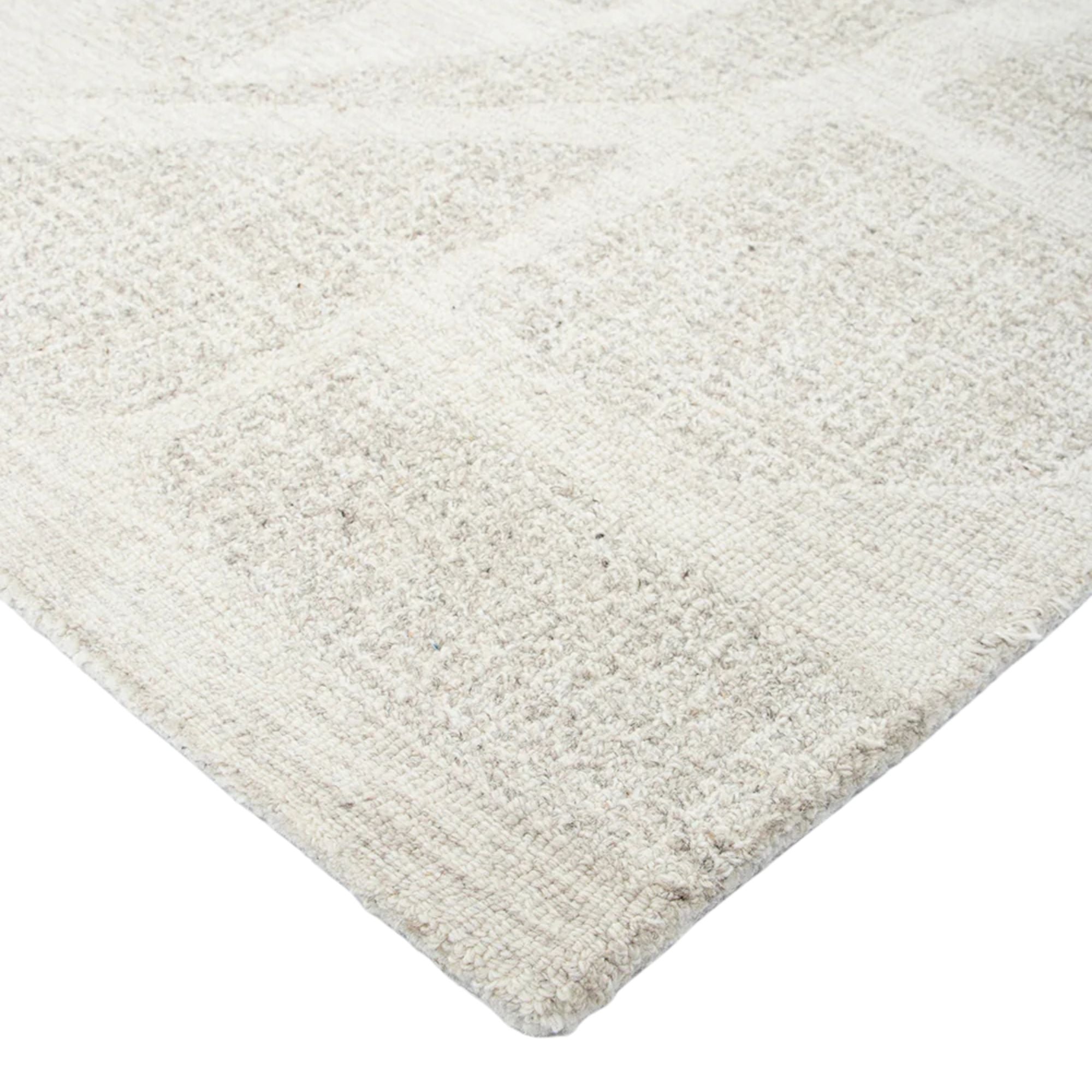 Close-up of a textured beige rug on a white background