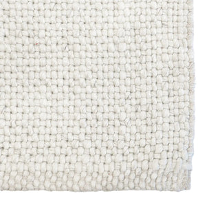 Close-up of a textured white rug with a woven pattern on a white background