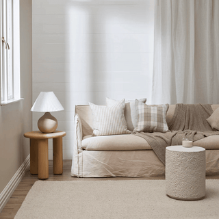 Beige sofa with decorative pillows in a living room setting