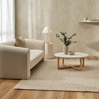 Modern living room with beige sofa, marble coffee table, and decorative elements.
