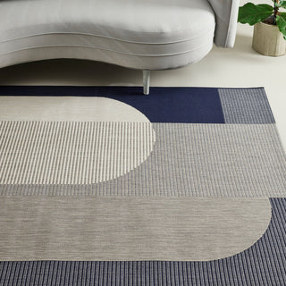 Geometric patterned rug with circular and rectangular shapes in a living room setting.