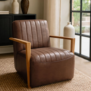Brown leather armchair with wooden arms in a room with a window and decorative vases.
